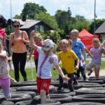 Zawodnicy przebiegają przez przeszkodę z opon Zawodnicy przebiegają przez przeszkodę z opon