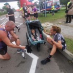 Zawodnik wykazuje szacunek dla zawodniczki, która pokonała trasę z dzieckiem w wózku biegowym Zawodnik wykazuje szacunek dla zawodniczki, która pokonała trasę z dzieckiem w wózku biegowym