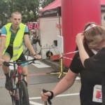 Rowerzysta zamykający bieg za ostatnią zawodniczką na mecie Rowerzysta zamykający bieg za ostatnią zawodniczką na mecie