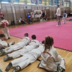 Młodzi zawodnicy kibicują koledze tuż przy macie Młodzi zawodnicy kibicują koledze tuż przy macie